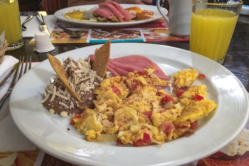 Café-da-manhã mexicano: ovos mexidos, presunto e feijão.