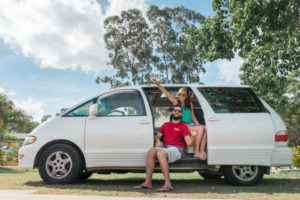 Tammíris e Rafael sentados na campervan estacionada em um camping na cidade de Agnes Water (Austrália).