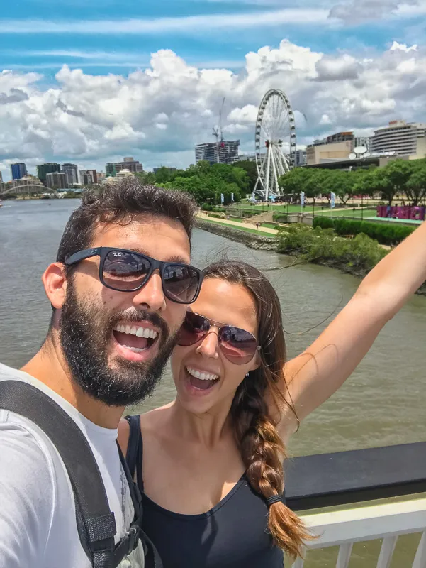Casal em South Bank com skyline de Brisbane ao fundo