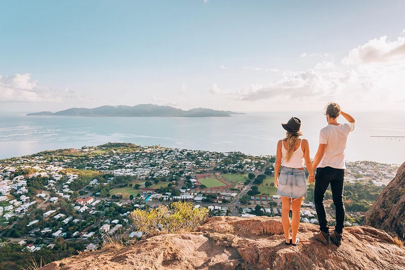 Casal observando a paisagem de Townsville, em Queensland, a partir do mirante de Castle Hill.
