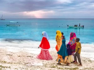 Mulheres com hijab coloridos caminhando na praia em Zanzibar