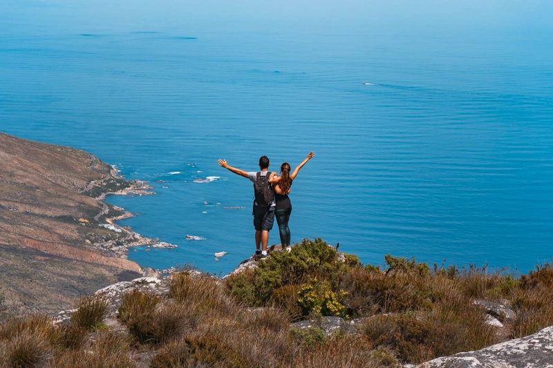 Tatá e Rafa de braços abertos no topo da Table Mountain, em Cape Town, na África do Sul.
