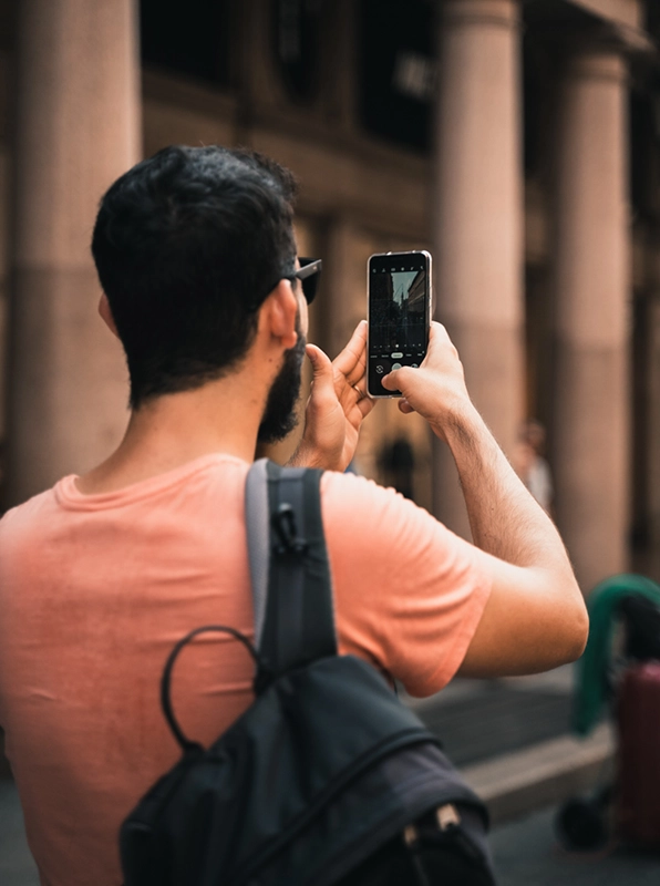 Rafa usando celular na Itália. Com um eSIM ou chip pré-pago você mantem seu celular conectado.
