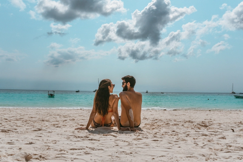 Tatá e Rafa, do Profundo no Mundo, sentados na praia de Nungwi, em Zanzibar
