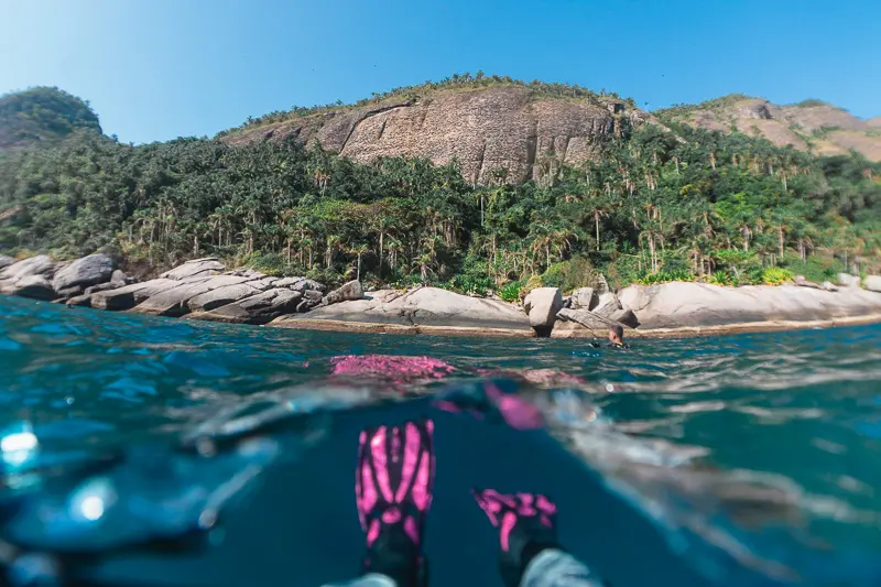 Nadadeira de mergulhadora flutuando em águas cristalinas em Alcatrazes.